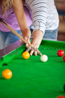 Attentive boyfriend teaching his girlfriend how to play pool