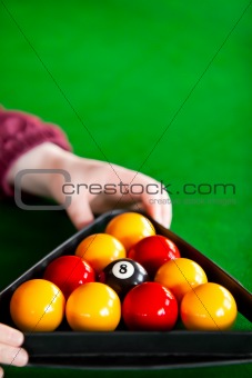 Close-up of a snooker player placing balls with triangle