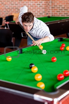 Concentrated young man playing snooker