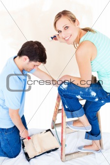 Beautiful couple painting a room