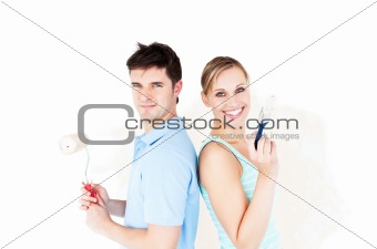 Charismatic couple painting a room
