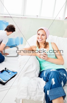 Relaxing smiling woman sitting on the sofa looking at the camera