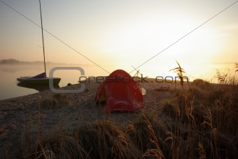 Tent and Boat on Shore at Sunrise