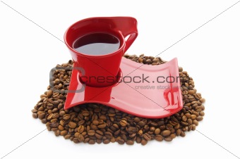 Cup of coffee with many beans around