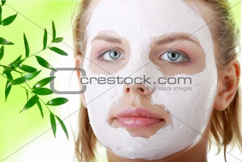 Young female face with clay mask