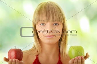 Young blond woman with red and green apples