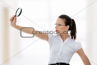 Business woman holding magnifying glass