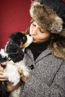 Woman kissing dog.