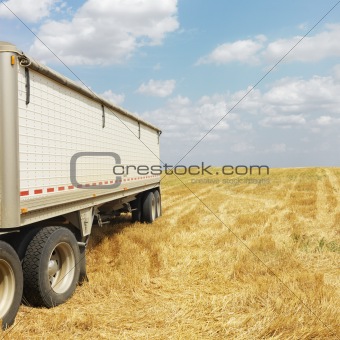 Tractor trailer truck in field.
