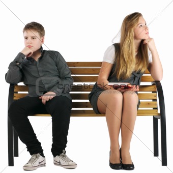 Boy and girl sitting on a bench and not looking at each other