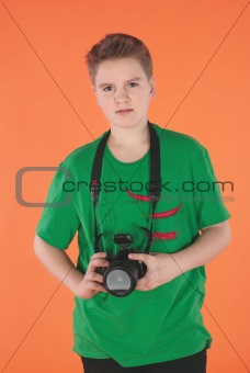 Boy with photo camera. Orange background