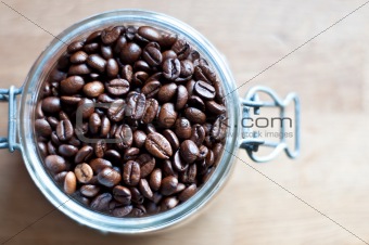 Rich dark coffee beans in a glass recipient