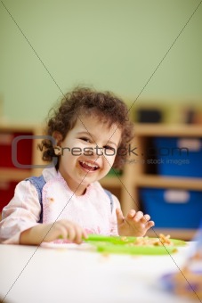 little girl eating lunch in kindergarten