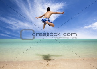 Happy young man jumping on the beach