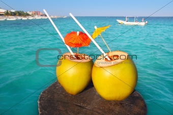 coconut cocktails in caribbean on wood pier