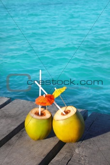 coconut coktails in caribbean on wood pier