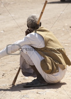 Local bedouin man sitting in road
