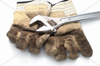 Dirty leather gloves and monkey wrench