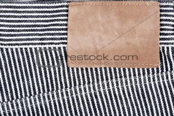 Blank leather jeans label sewed on a striped jeans 