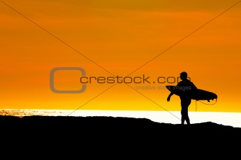 Surfer heading to sea for a sunset ride