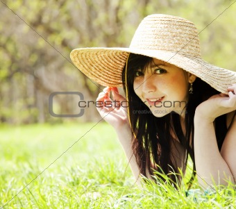 Beautiful brunette girl in hat at the park.