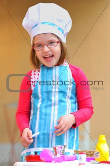Little girl having fun playing cooking