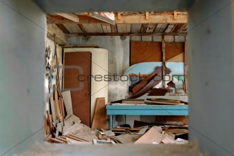 ramshackled room with boarded up window 