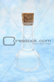 Bottle of clean  water  in water ripples over colored background