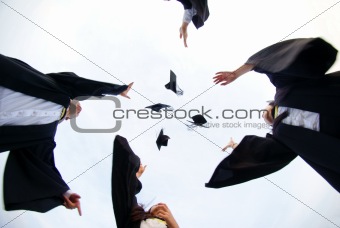 Happy asian graduates throw hats