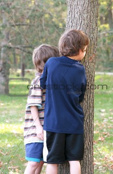 Boys Peeking Around Tree