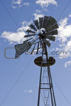 Windmill against clouds in sky