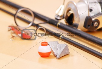 Fishing Weights and Floater Next to Black Fishing Rod