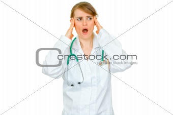 Shocked medical doctor woman with hands at head looking at copy space
