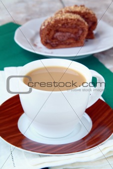 tea with milk in a white cup on a green tablecloth