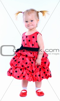Cute little girl in a red dress. In the studio. Isolated