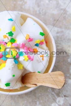ice cream in a white cup with multi-colored candies