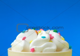 ice cream in a white cup with multi-colored candies