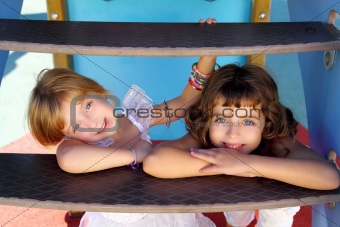 blue eyes little sister girls similing in playground stairs