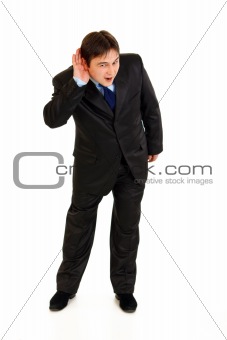 Full length portrait of stressful businessman holding hand at ear and listening
