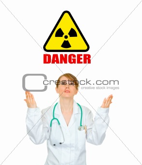 Concept- radiation danger! Frustrated medical doctor woman looking up and  raising her hands
