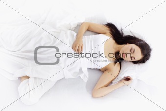 Young woman sleeping on white bed