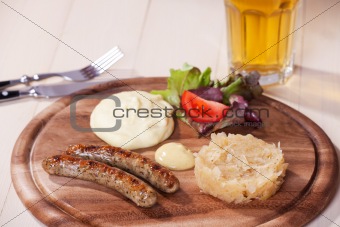 two bratwurst sausages on a wooden plate