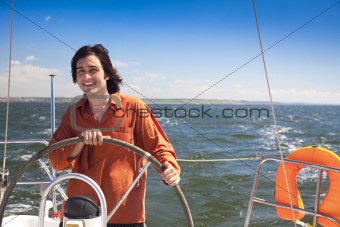 Young  skipper driving sailboat 