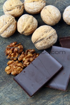 walnuts and dark chocolate on a wooden background