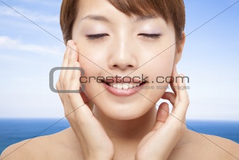 Beautiful Woman Face closeup and blue ocean background