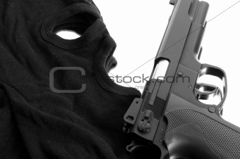 Pistol and mask of a thief over white