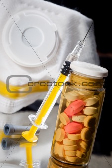 Medicine bottle and sirynge and pills and mask