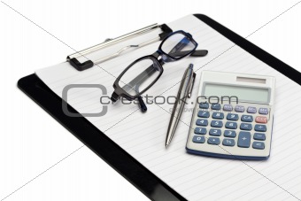 Angled note pad, pen, glasses and pocket calculator