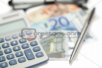 Money, pen, glasses and angled pocket calculator