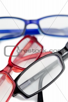 Three pairs of glasses with blue red and black frames